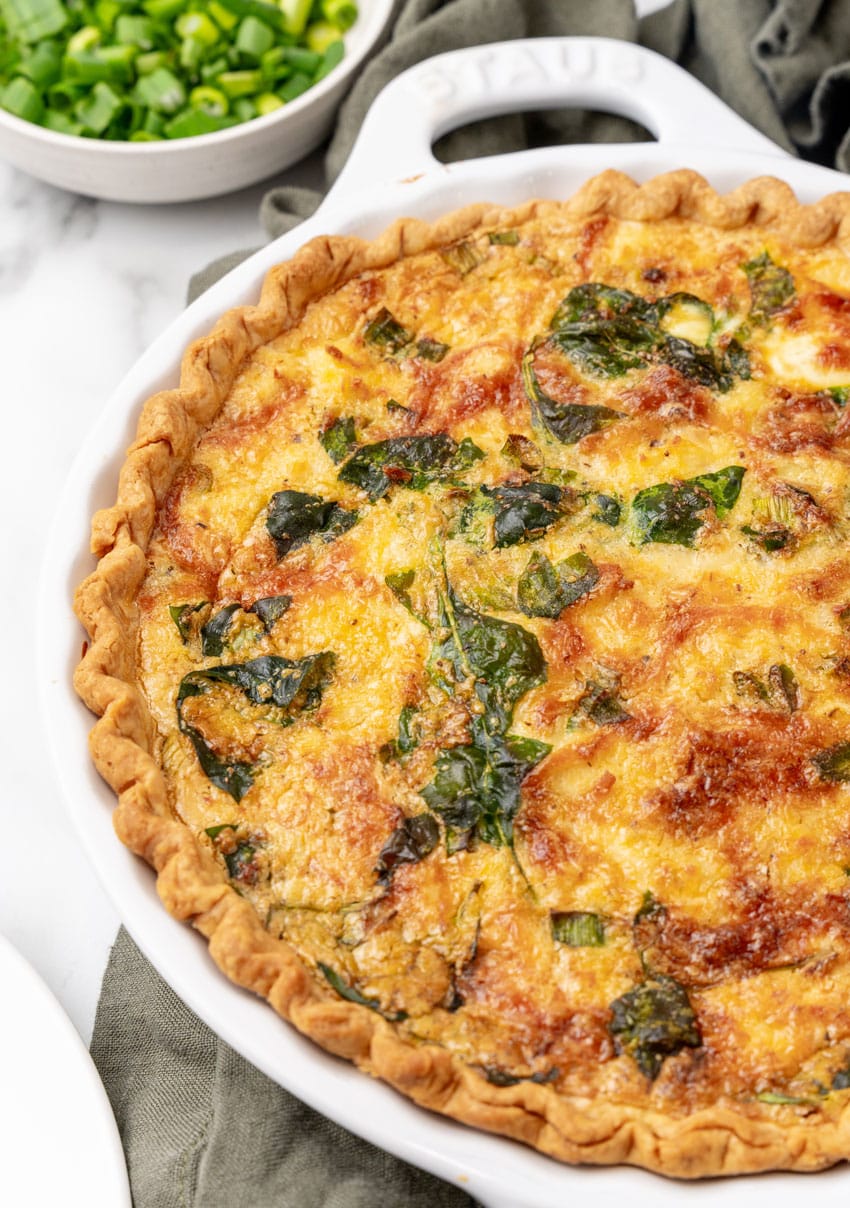 a baked crab quiche in a white pie dish