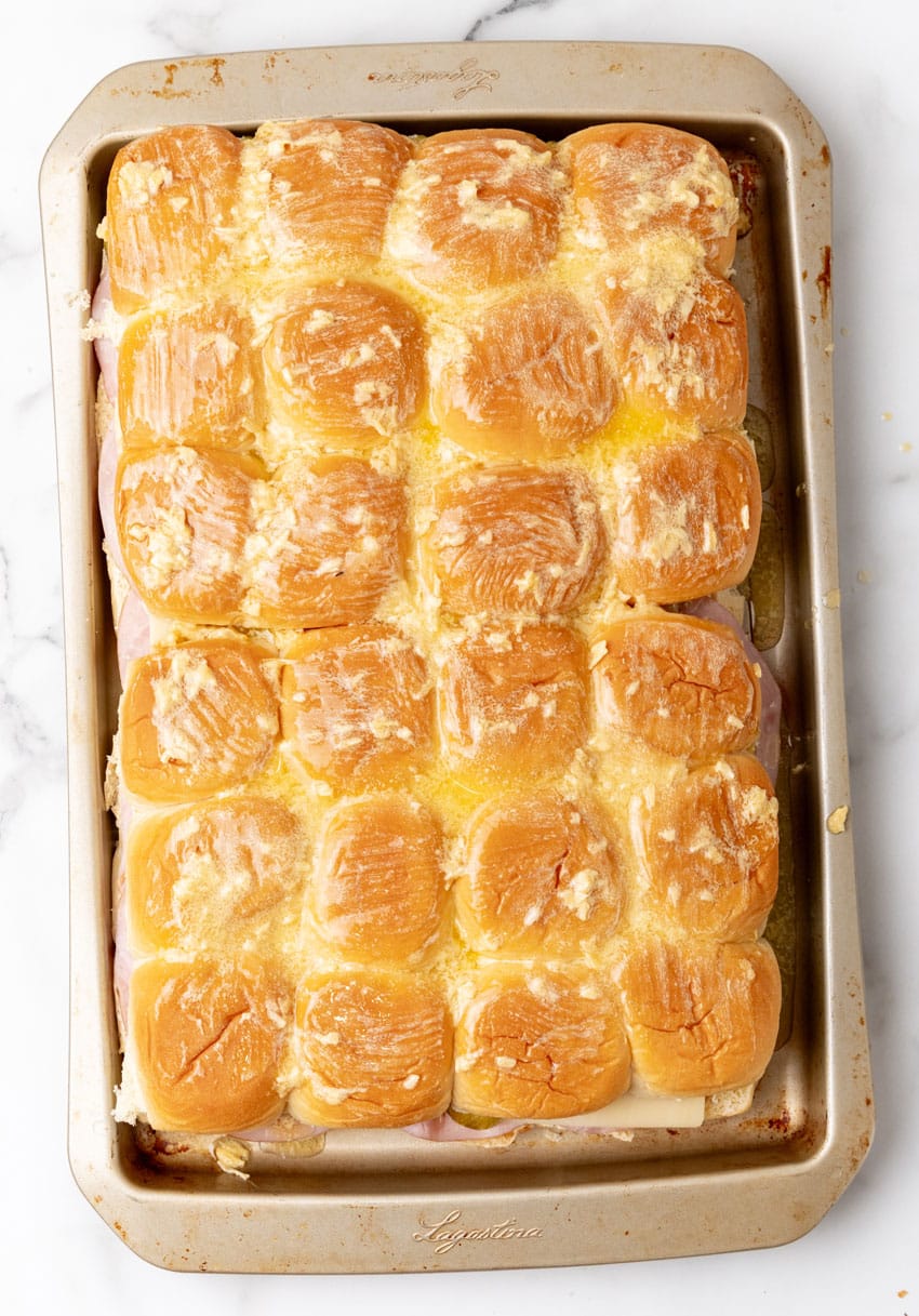 cuban style sliders on hawaiian rolls on a rimmed baking sheet