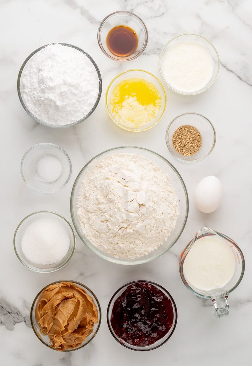 an overhead image showing the measured ingredients needed to make a batch of glazed peanut butter and jelly rolls