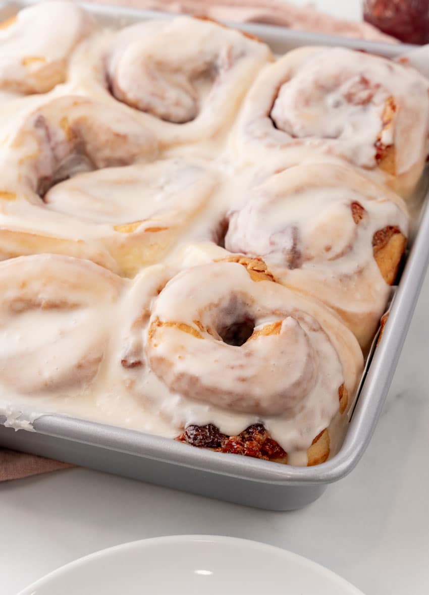 glazed peanut butter and jelly rolls in a silver baking pan