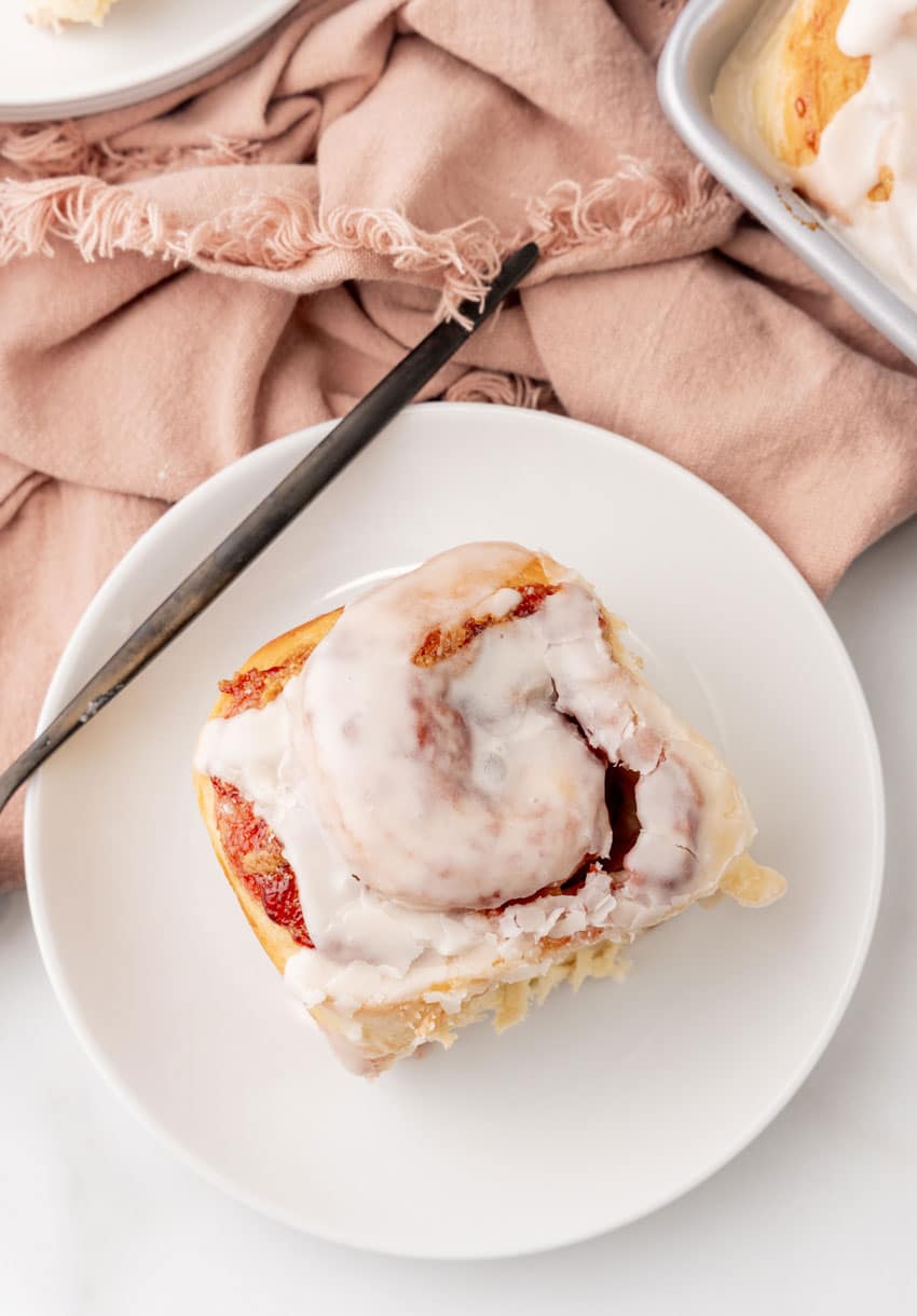 a glazed peanut butter and jelly sweet roll on a small white dessert plate