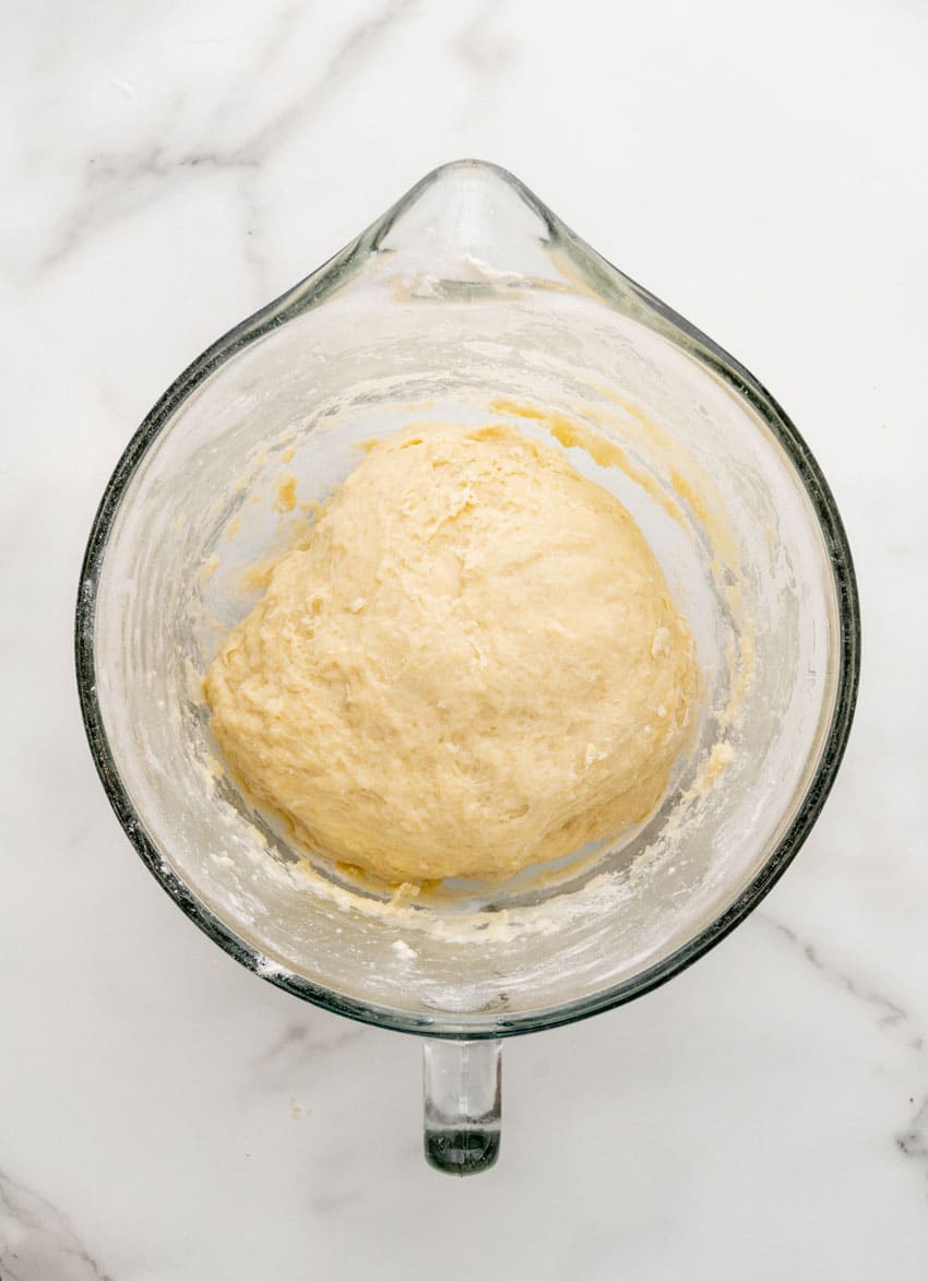 proofing sweet roll dough in a glass mixing bowl