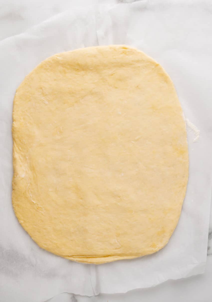 sweet roll dough rolled out on parchment paper