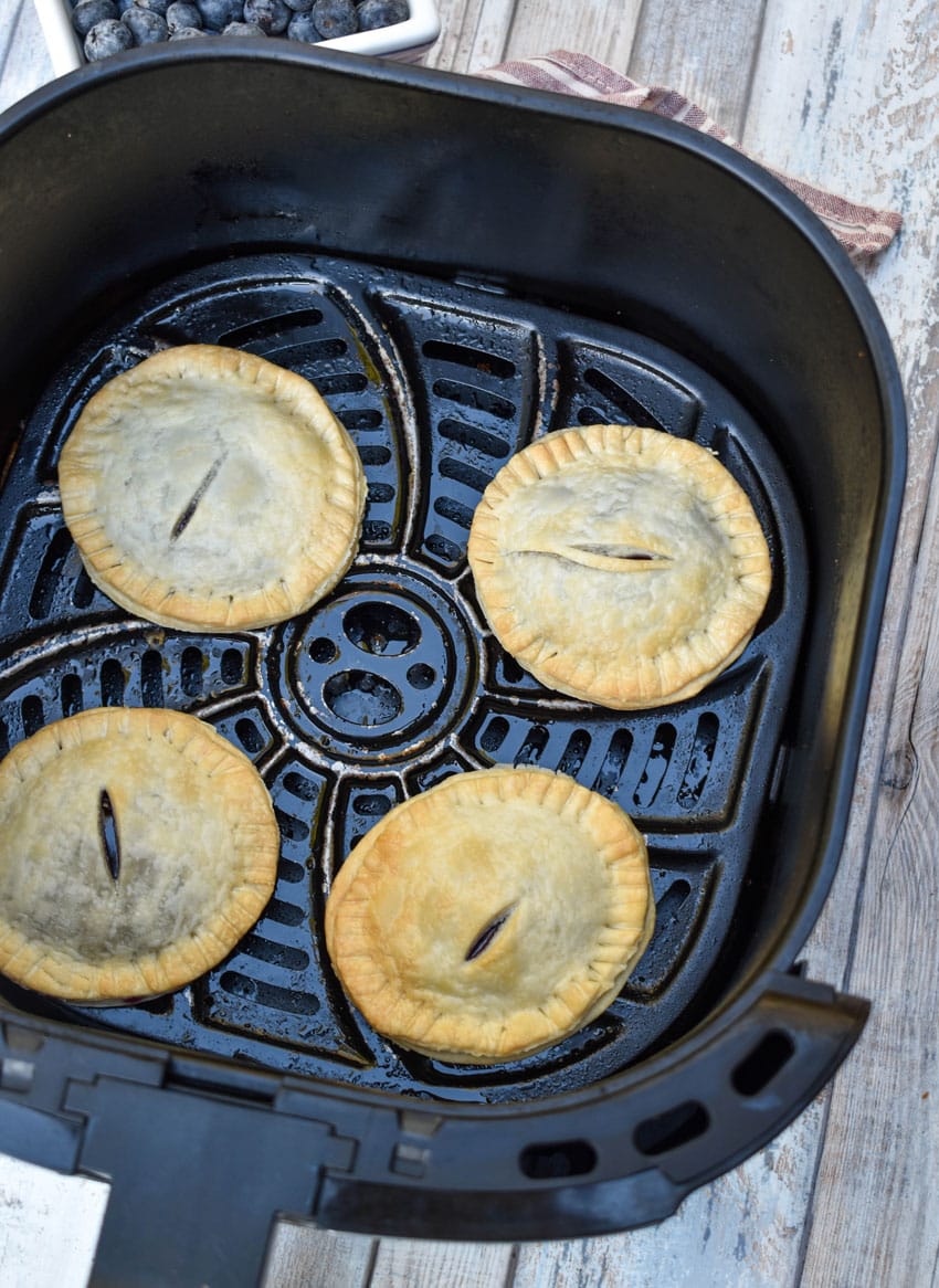 baked blueberry filled hand pies in the basket of an air fryer