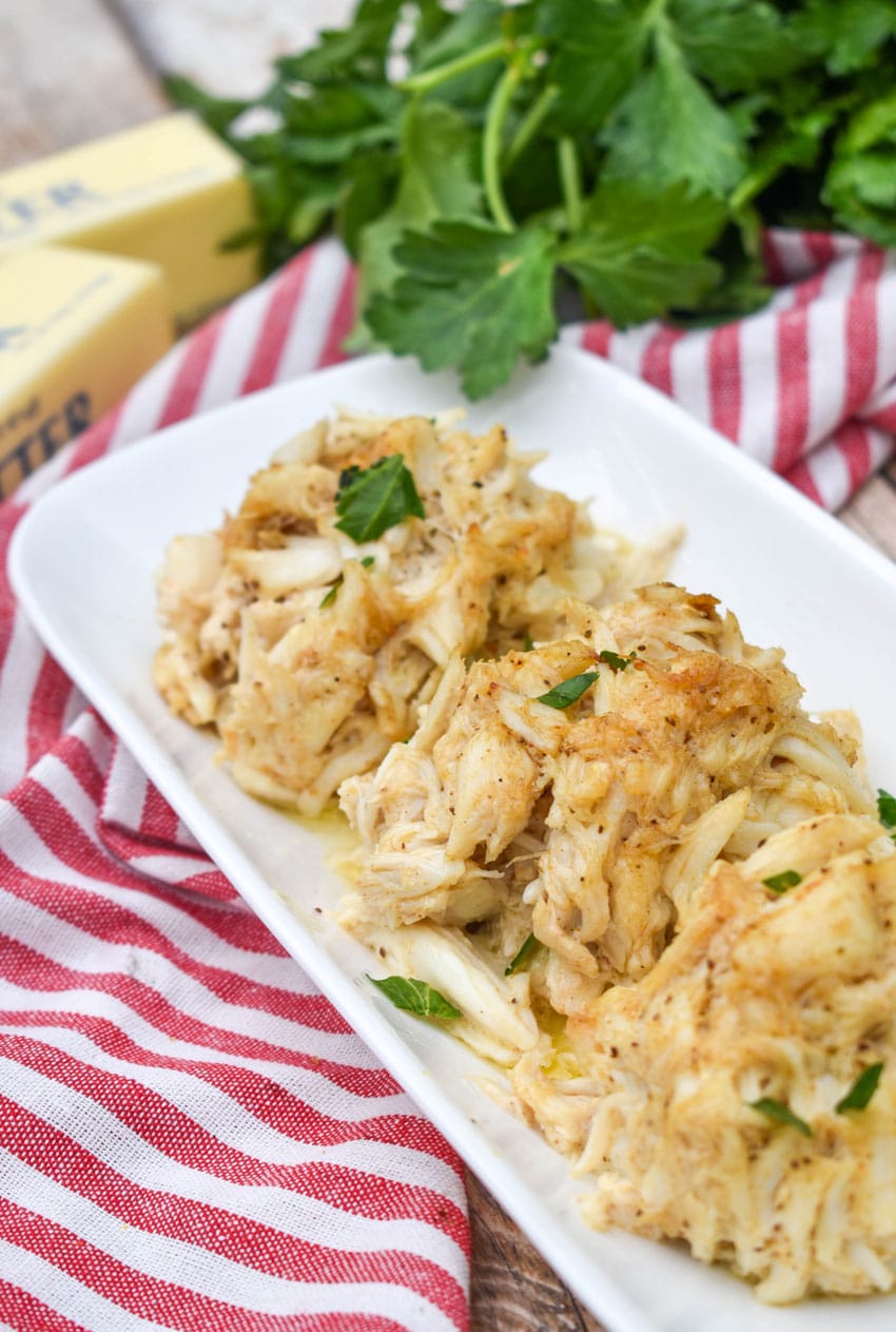 three baked lump crab cakes on a narrow white serving plate
