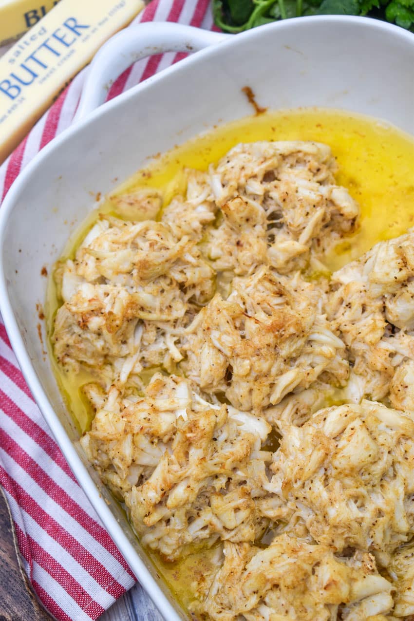 baked lump crab cakes in butter in a white casserole dish