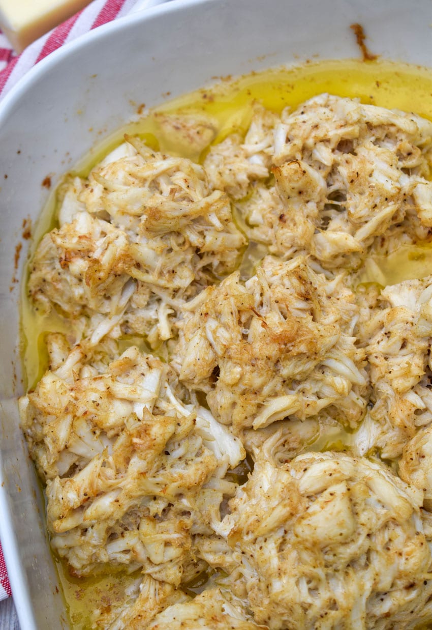 baked lump crab cakes in butter in a white casserole dish