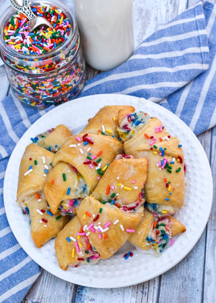 funfetti cheesecake stuffed crescent rolls piled on a small white plate