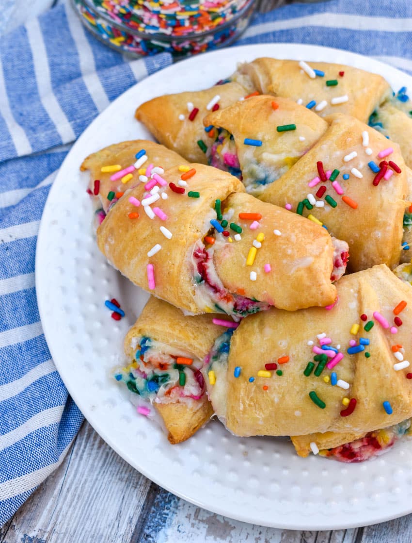 glazed funfetti crescent rolls piled on a small white plate