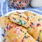 funfetti cheesecake stuffed crescent rolls piled on a small white plate