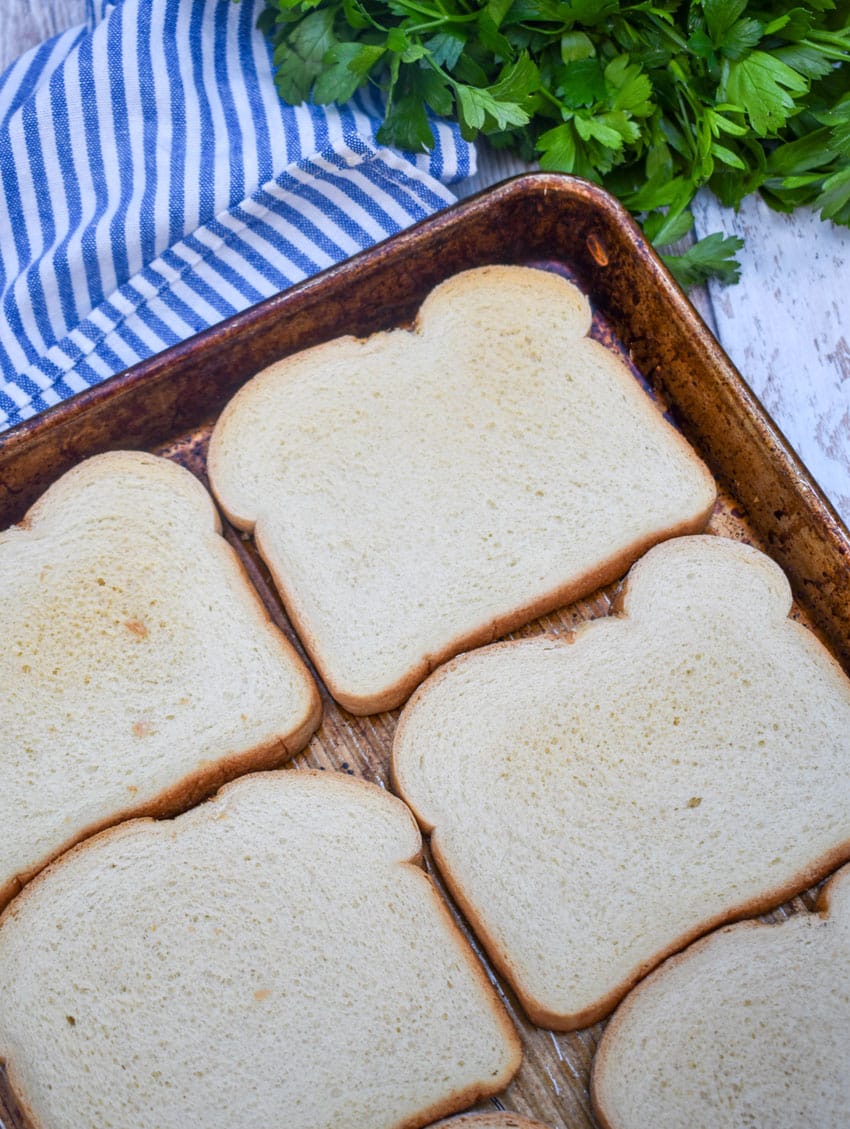 slices of white sandwich bread on a rimmed metal baking sheet