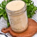 homemade bread crumbs in a glass mason jar sitting on a small wooden trivet