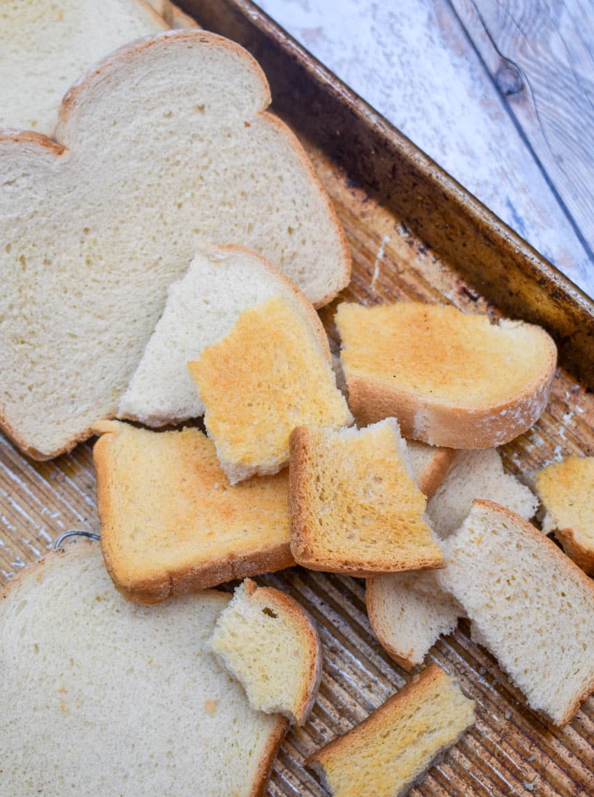 broken pieces of toasted bread on a rimmed metal sheet pan