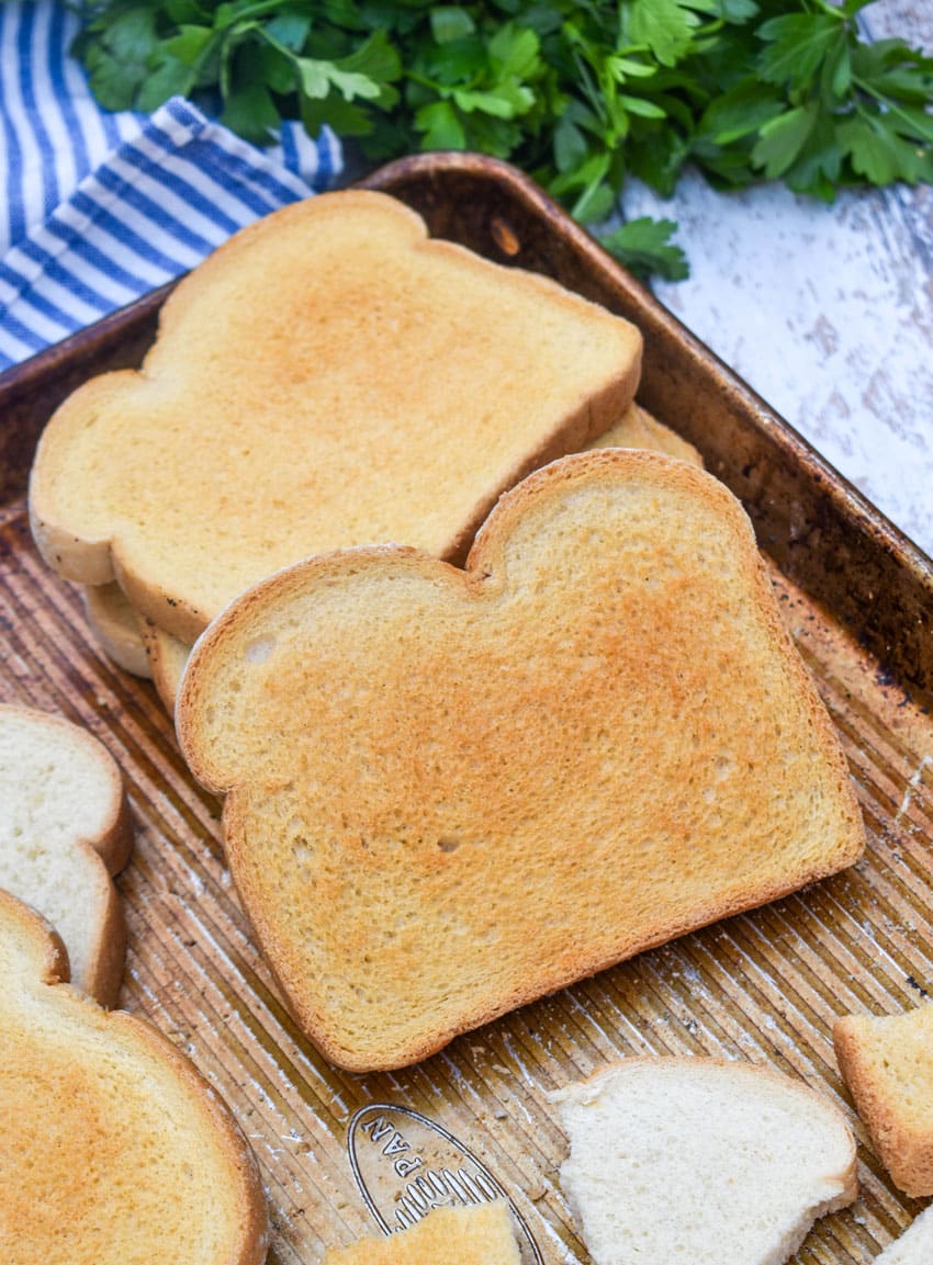 slices of toasted white sandwich bread on a rimmed metal baking sheet