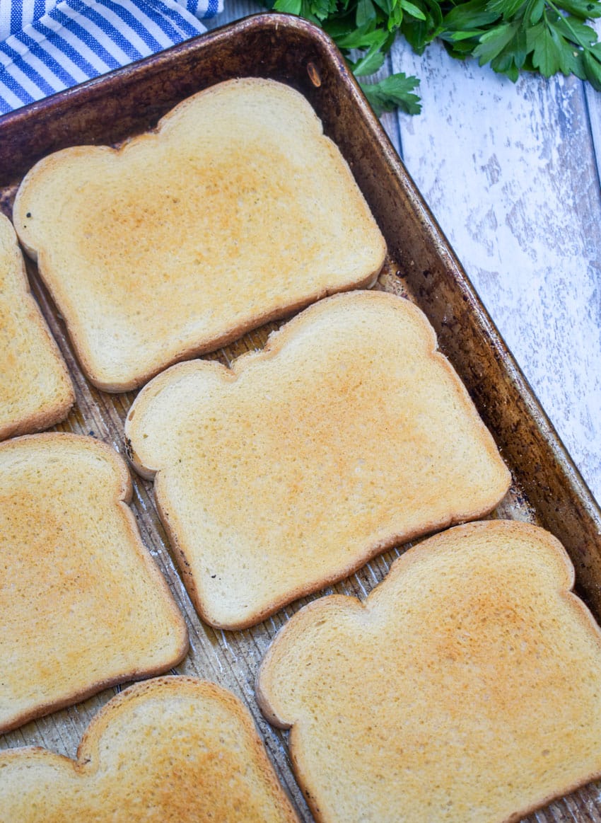 slices of toasted white sandwich bread on a rimmed metal baking sheet