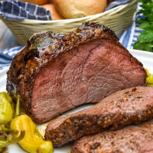a sliced smoked mississippi chuck roast on a white serving plate