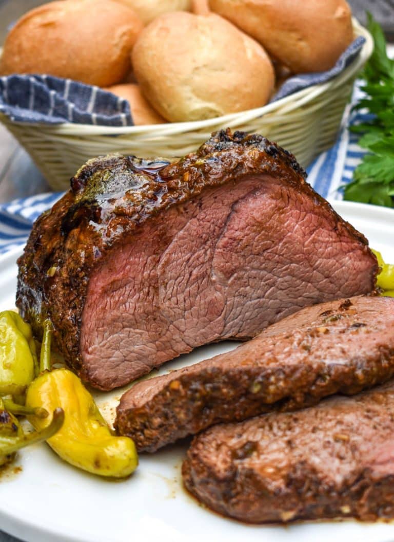 a sliced smoked mississippi chuck roast on a white serving plate