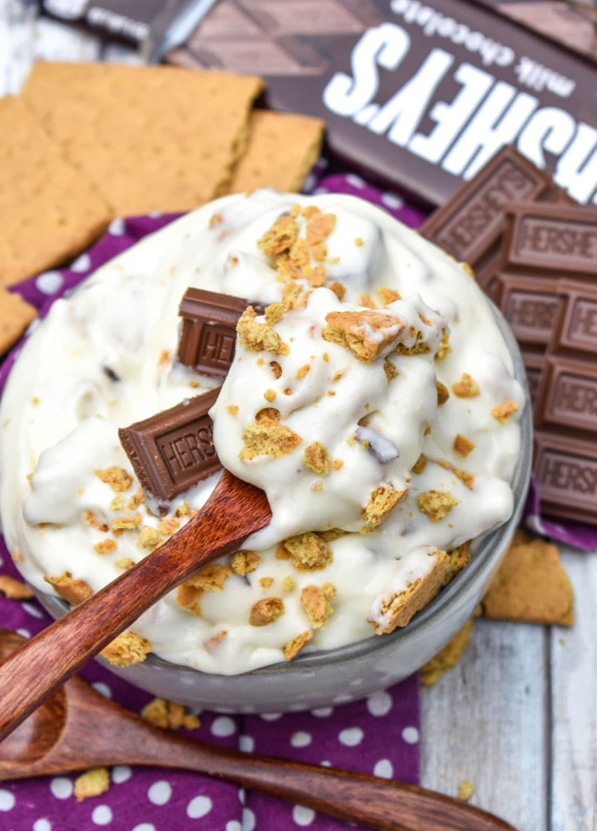 a wooden spoon scooping s'mores fluff salad out of a small white bowl