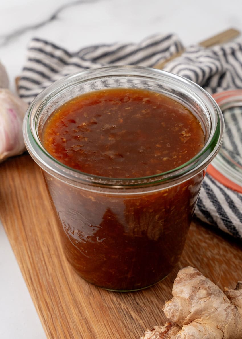 homemade teriyaki sauce in a small glass jar on a wooden cutting board