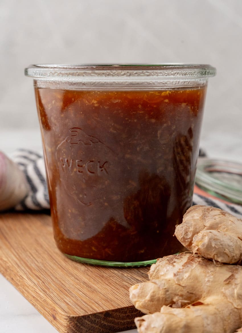 homemade teriyaki sauce in a small glass jar on a wooden cutting board