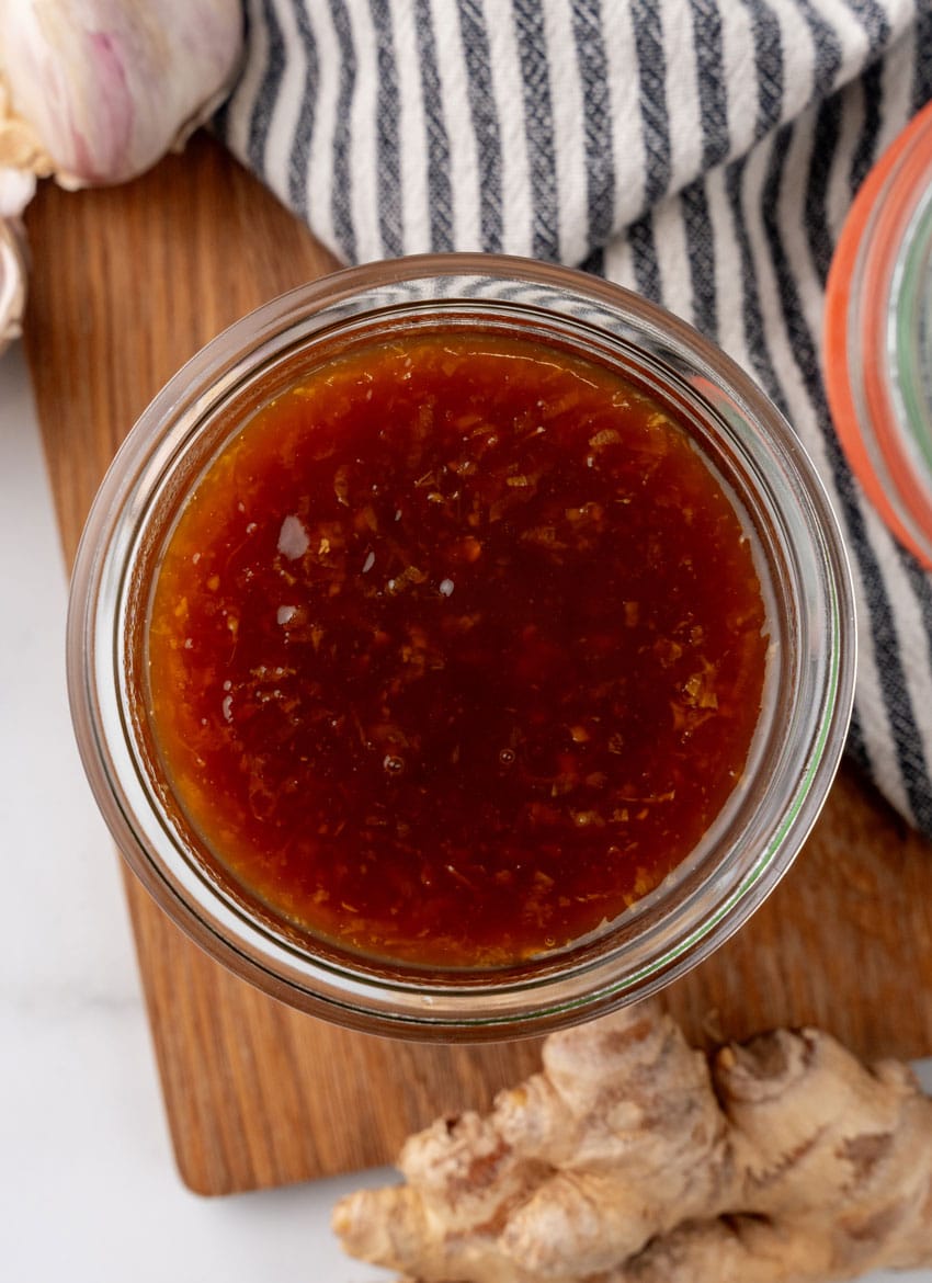 homemade teriyaki sauce in a small glass jar on a wooden cutting board