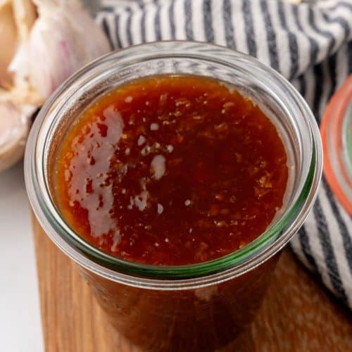homemade teriyaki sauce in a small glass jar on a wooden cutting board