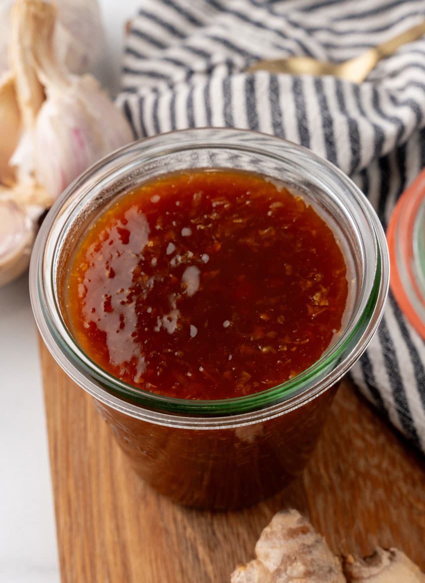homemade teriyaki sauce in a small glass jar on a wooden cutting board