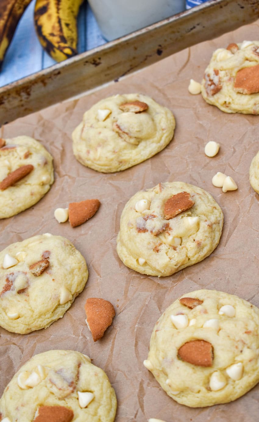 homemade banana pudding cookies arranged in rows on a parchment paper lined baking sheet