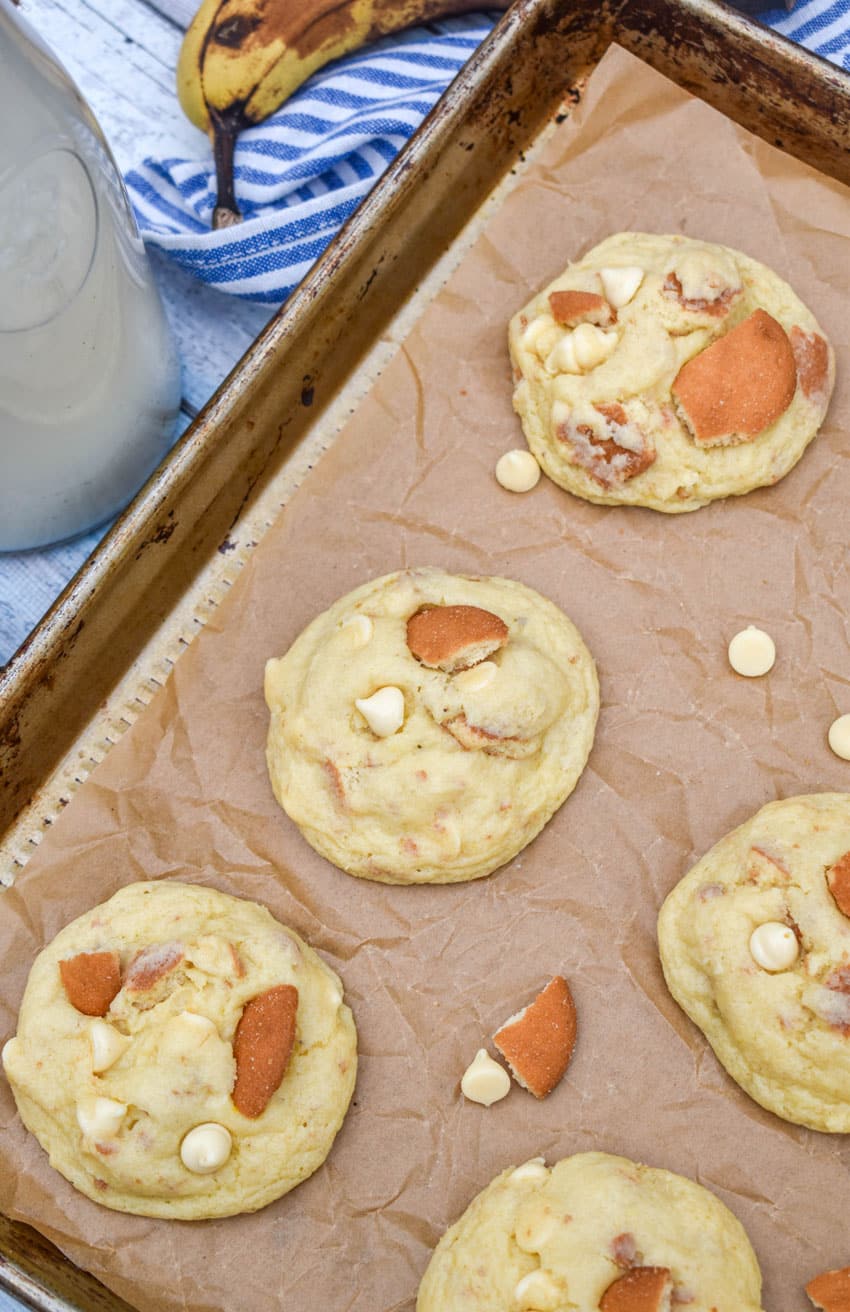 homemade banana pudding cookies arranged in rows on a parchment paper lined baking sheet