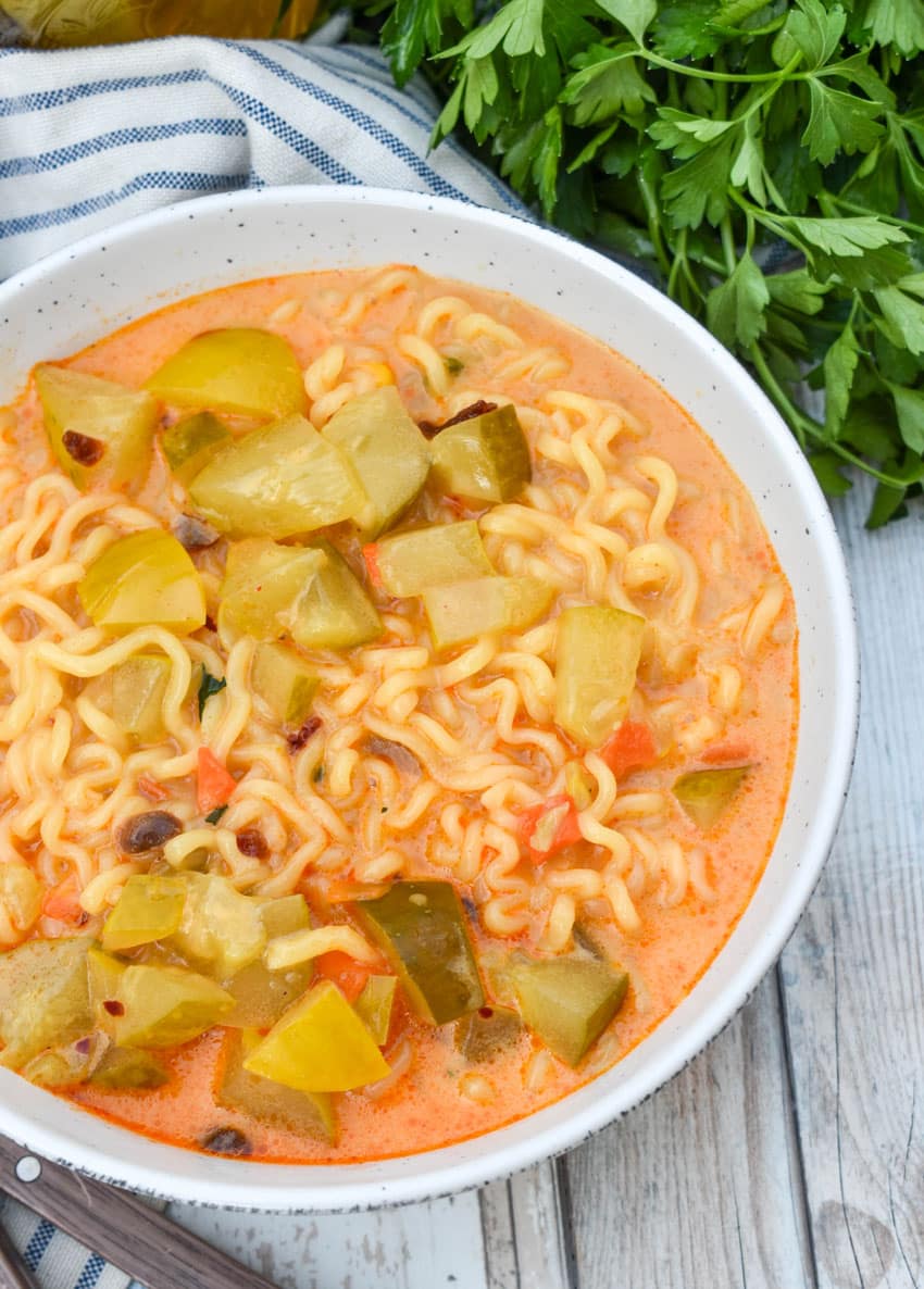 cheesy dill pickle ramen in a white soup bowl