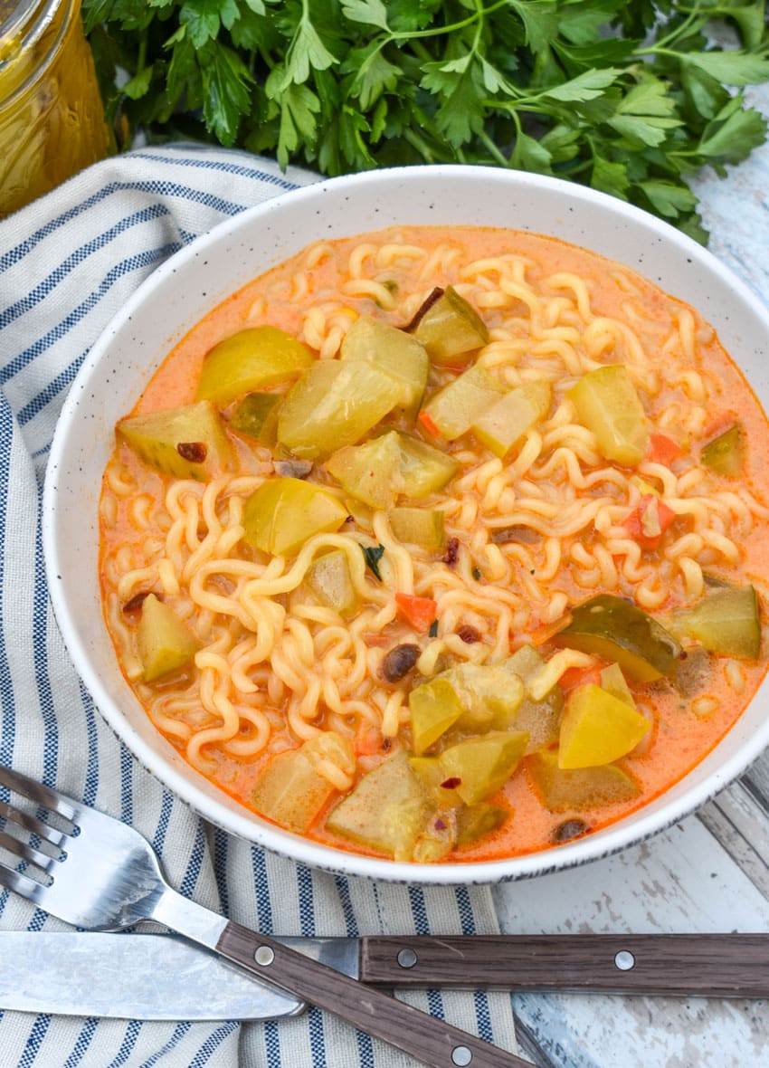 cheesy dill pickle ramen in a white soup bowl
