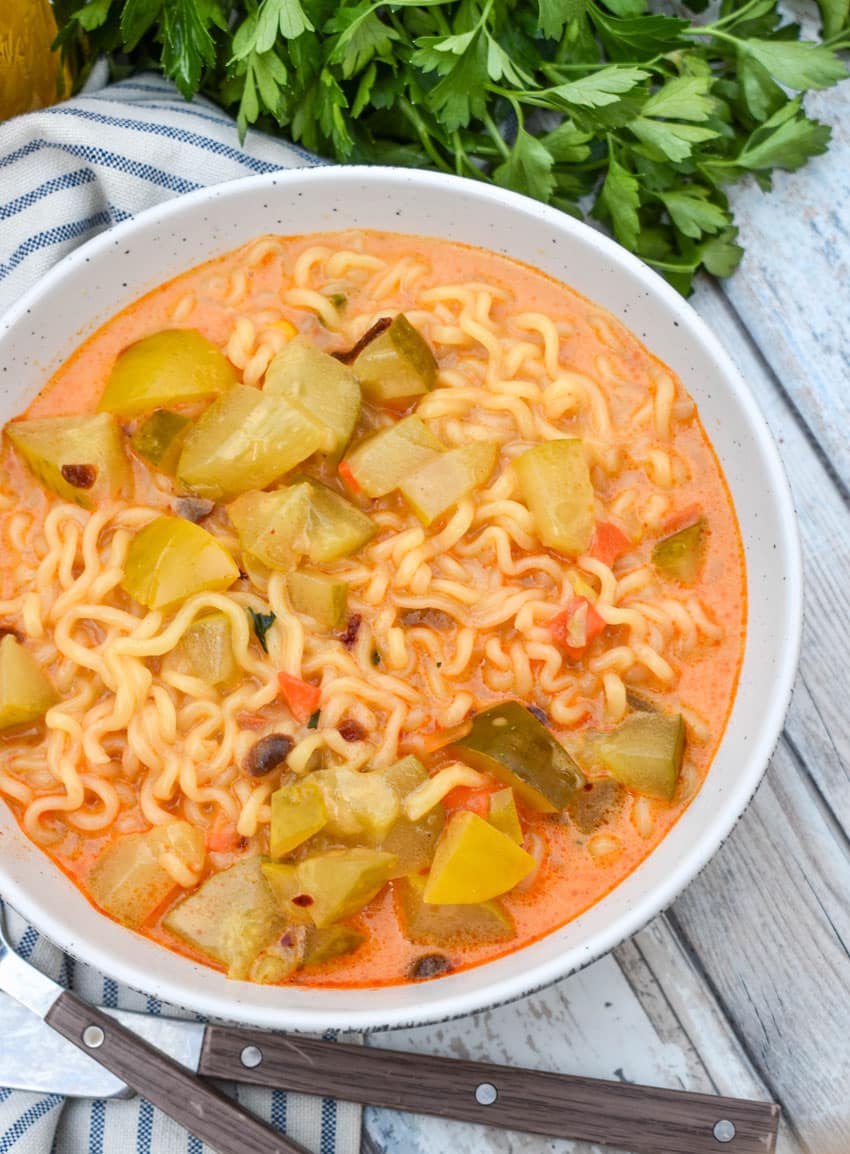 cheesy dill pickle ramen in a white soup bowl