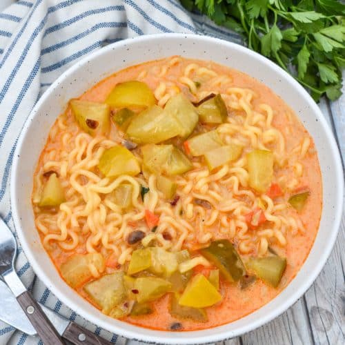 cheesy dill pickle ramen in a white soup bowl
