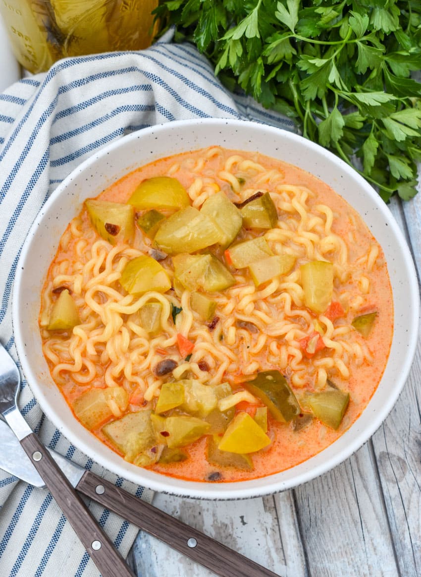 cheesy dill pickle ramen in a white soup bowl