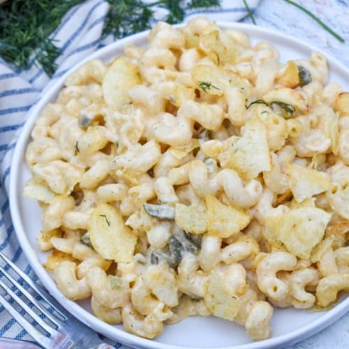 potato chip topped dill pickle macaroni and cheese on a white plate