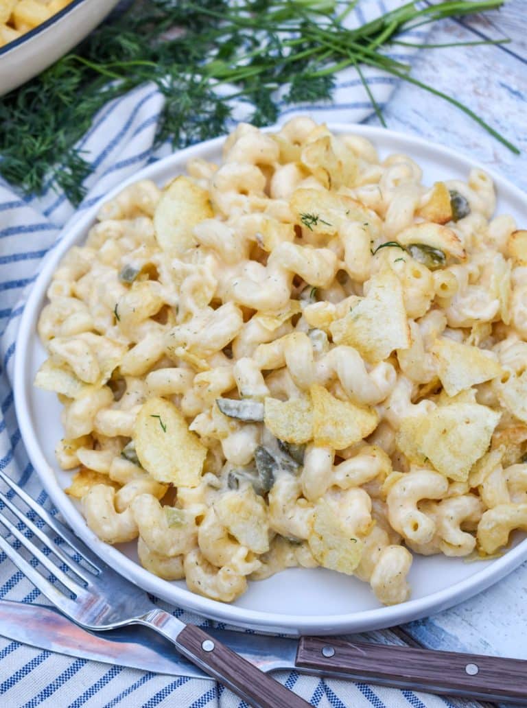 potato chip topped dill pickle macaroni and cheese on a white plate