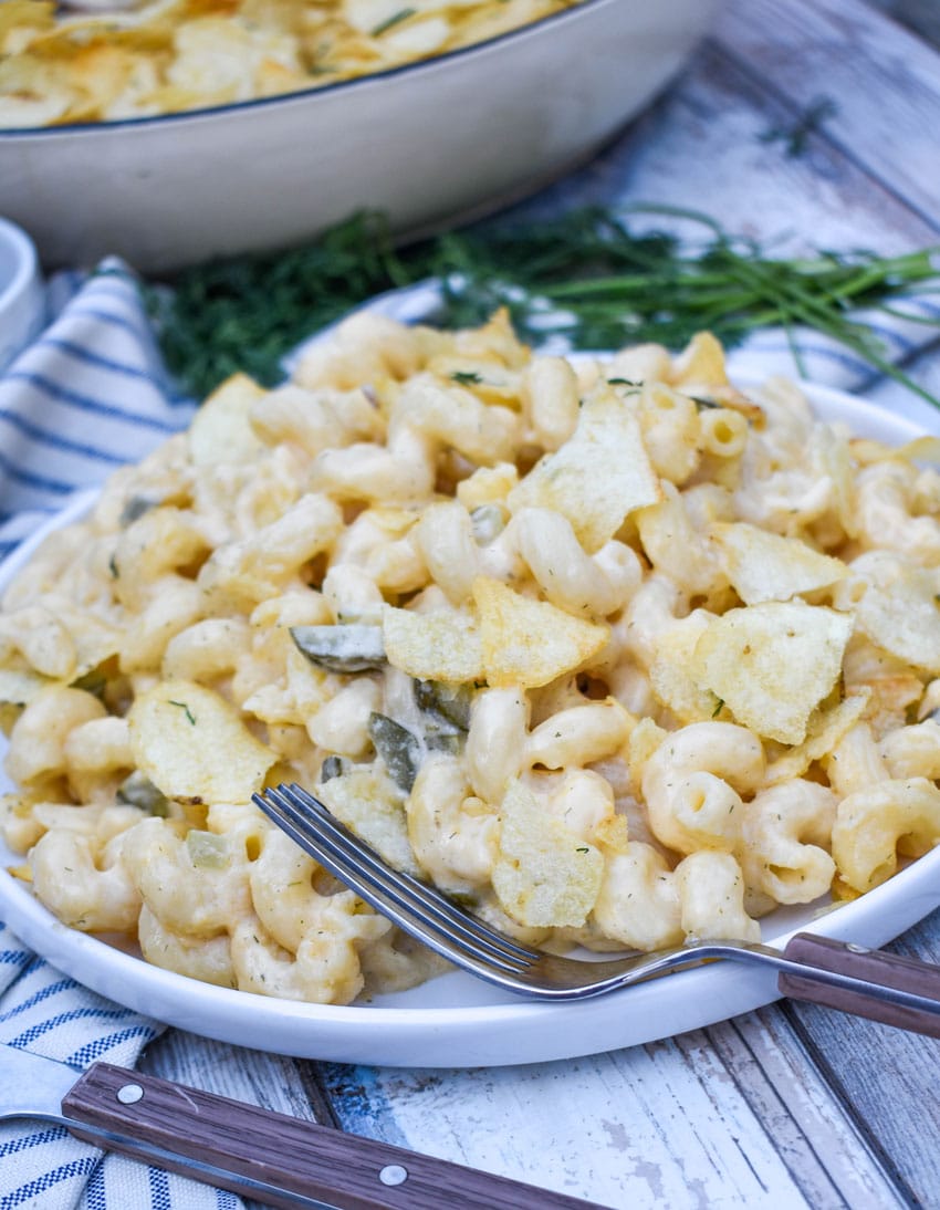 potato chip topped dill pickle macaroni and cheese on a white plate