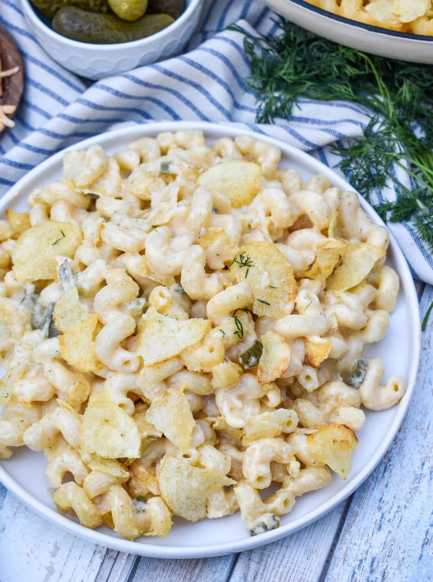 potato chip topped dill pickle macaroni and cheese on a white plate