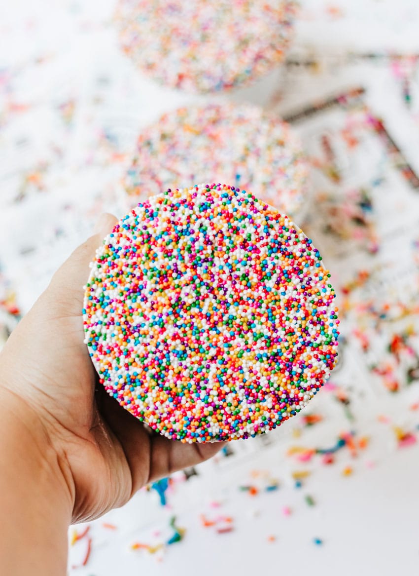 a hand holding up a homemade dotcup in a small white ramekin