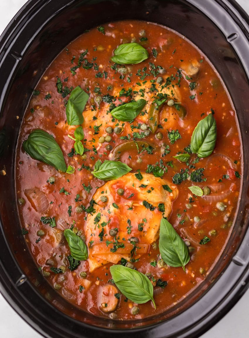 homemade chicken cacciatore in the black bowl of a slow cooker
