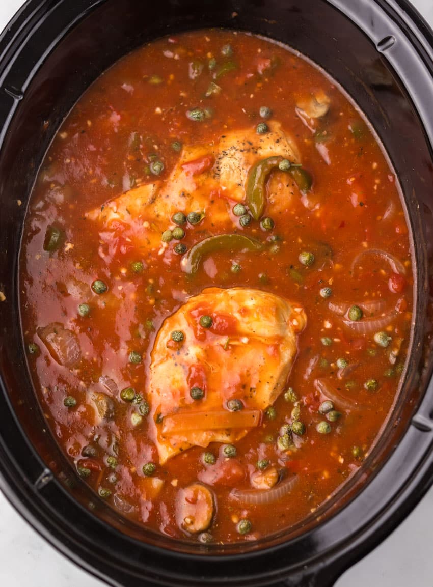 homemade chicken cacciatore in the black bowl of a slow cooker