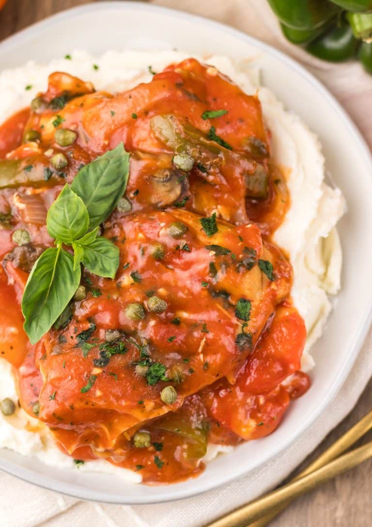slow cooker chicken cacciatore over mashed potatoes on a white plate