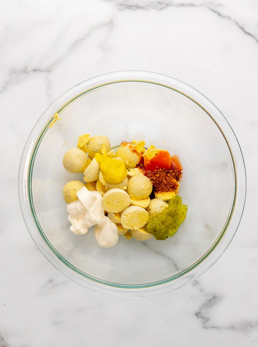 deviled egg filling ingredients in a glass mixing bowl