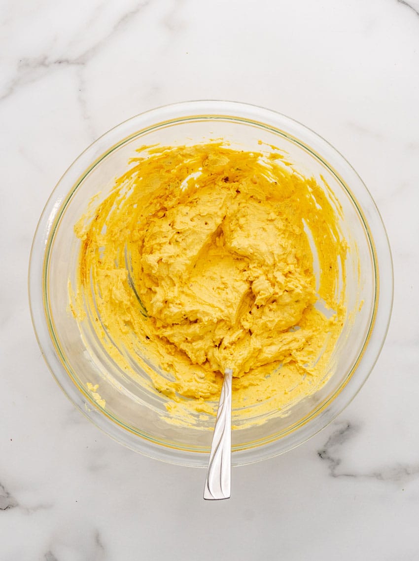 creamy deviled egg filling in a glass mixing bowl