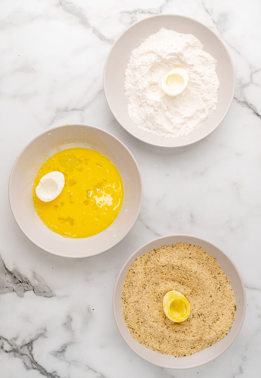 hard boiled egg whites in bowls of flour, beaten egg, and panko bread crumbs