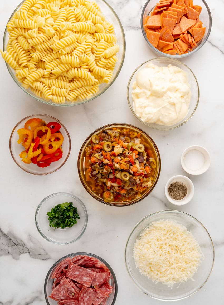 an overhead image showing the measured ingredients needed to make a batch of homemade muffuletta pasta salad