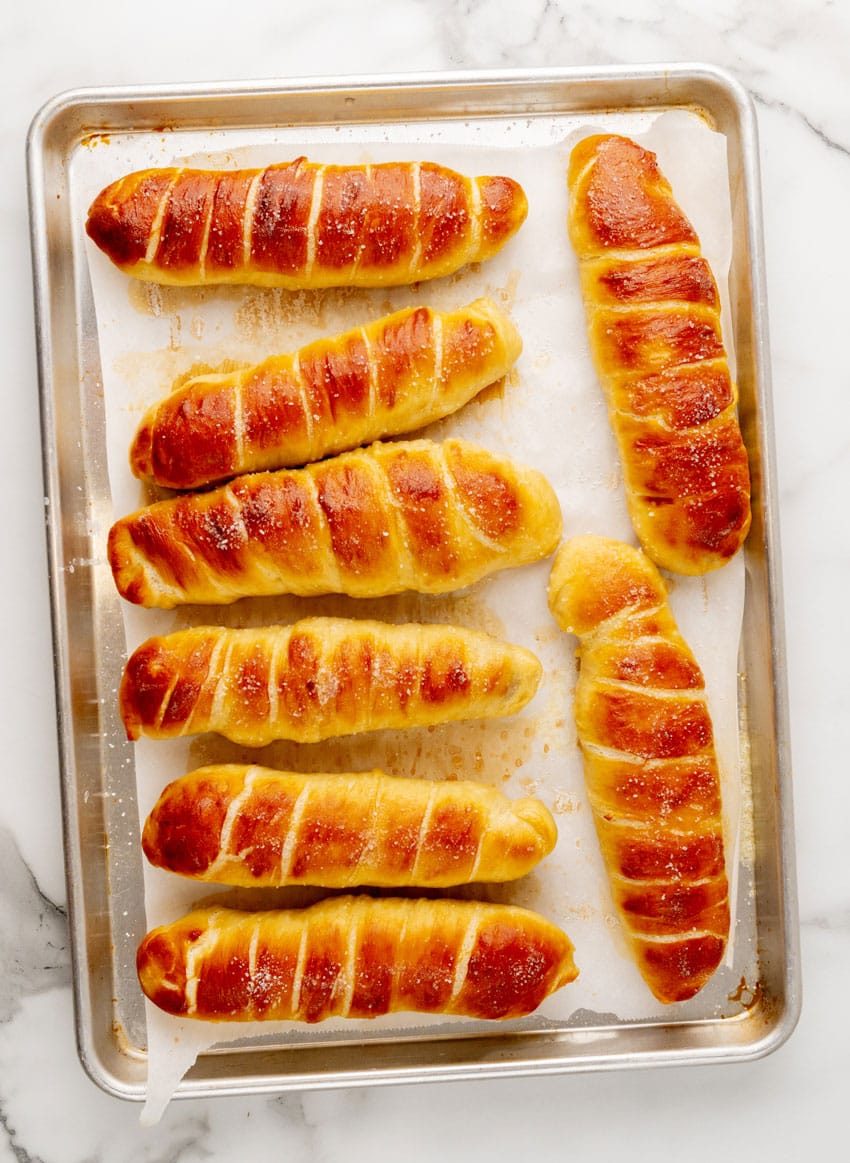 baked pretzel dogs on a parchment paper lined baking sheet