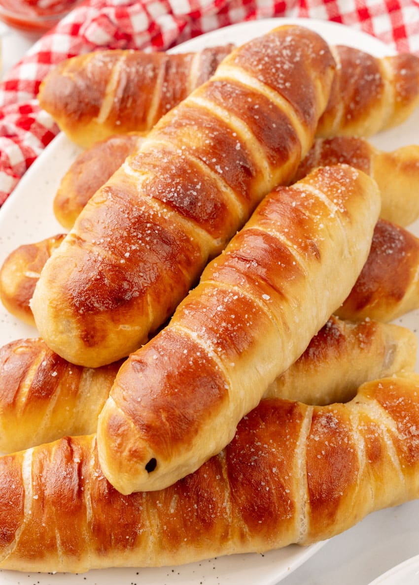 copycat Auntie Anne's pretzel dogs stacked on a white serving platter