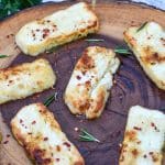 slices of air fried halloumi cheese on a wooden cutting board