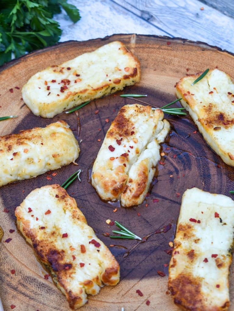slices of air fried halloumi cheese on a wooden cutting board